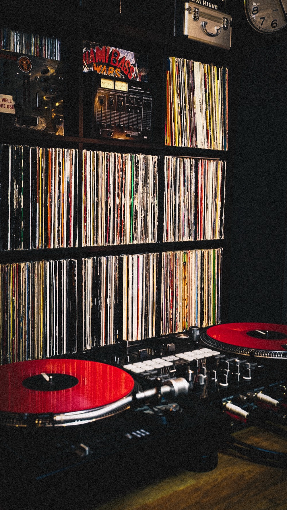 Turntables in front of the record wall